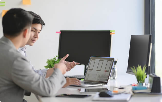 two men reviewing on a computer